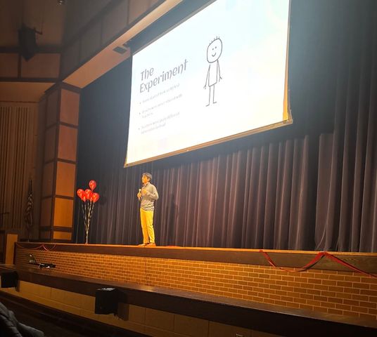 UHS student presenting his TEDx slideshow to students, teachers, and other viewers.