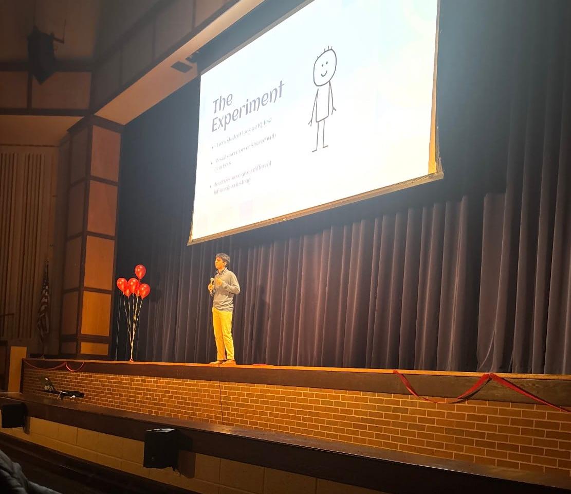 UHS student presenting his TEDx slideshow to students, teachers, and other viewers.